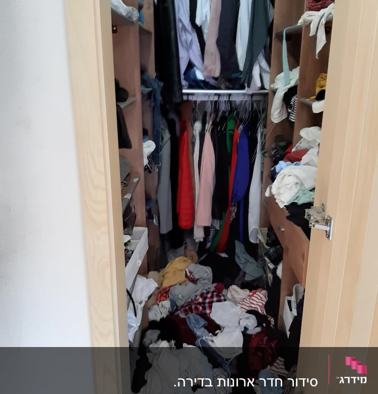 ארון בגדים מבולגן עם בגדים על הרצפה